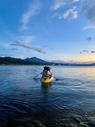 Dos personas en kayak en el embalse al atardecer