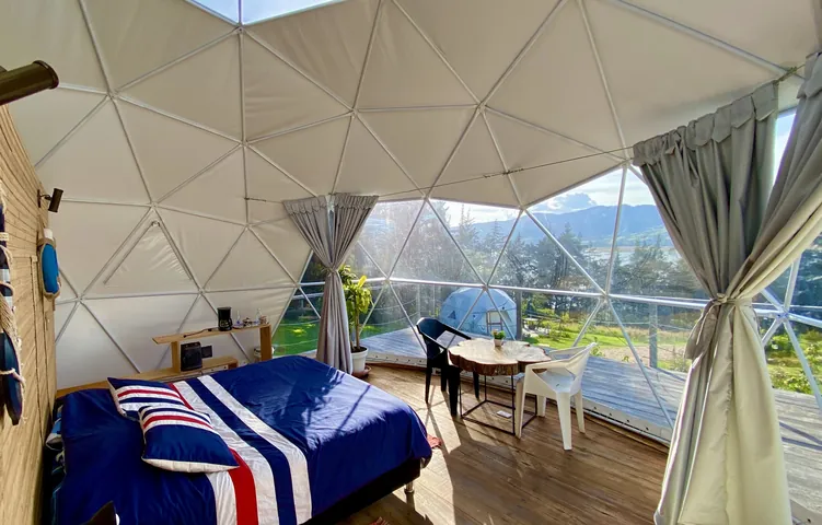 La cama queen del Domo Corbeta, frente a la ventana